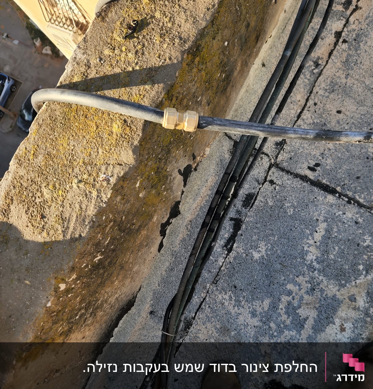 צינור עם מחבר מתכת על גג בטון